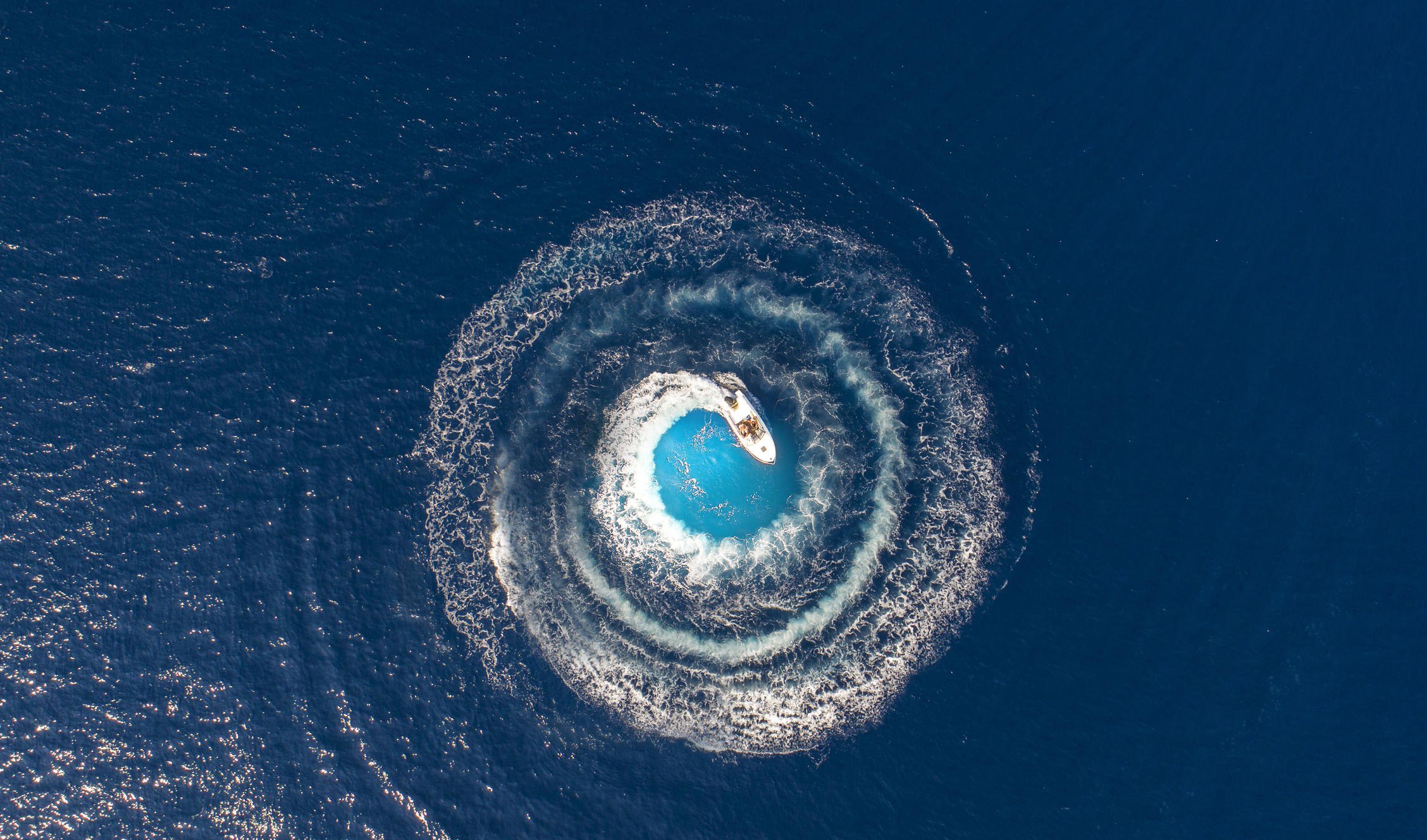 A Boat Is Driving In A Circle And Produces A Big Whirlpool