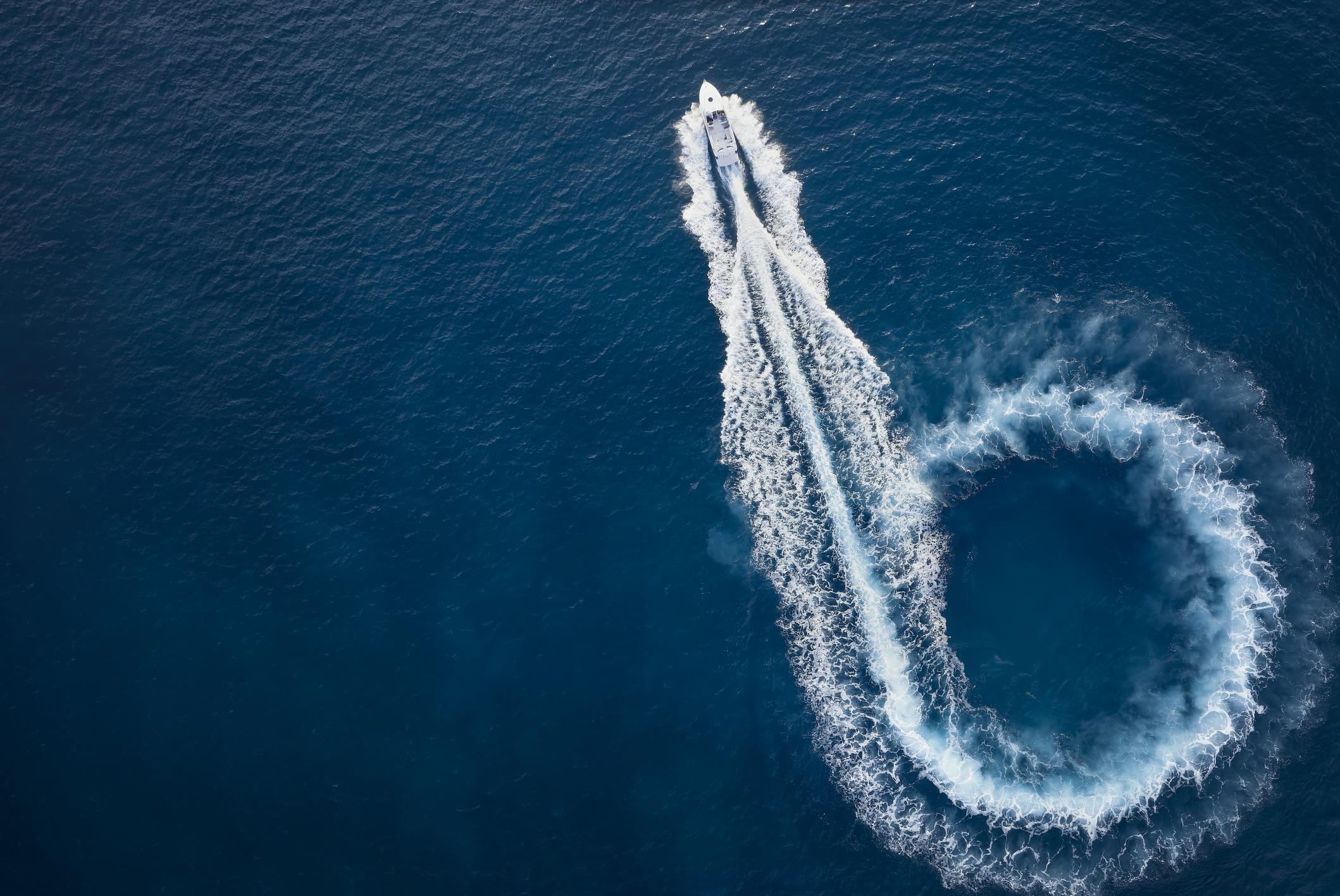 Aerial Top View Of A Motor Powerboat Forming A Circle Of Waves
